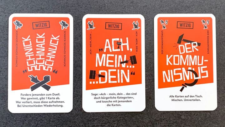 Drei nicht-witzige Spielkarten. Von links nach rechts: Schnick-Schnack-Schnuck, "Ach - mein, dein" und Kommunismus.